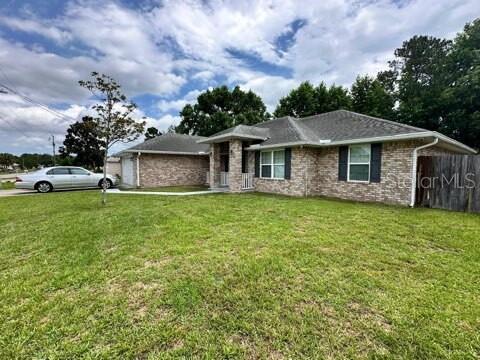 A single-story brick house with a hip roof and a front-facing garage — 41 PRIMROSE, PALM COAST, FL