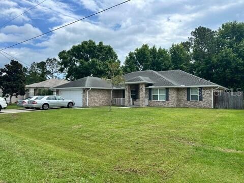 A single-story brick house with a gray shingled roof sits on a large grassy lot — 41 PRIMROSE, PALM COAST, FL
