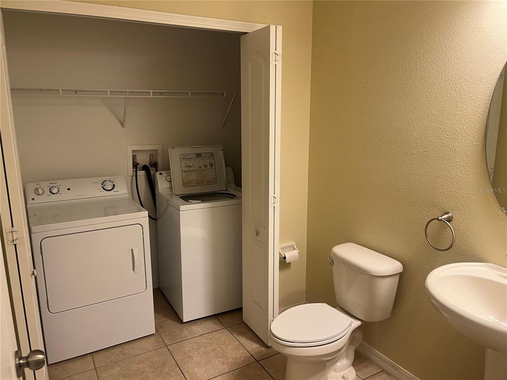 A laundry closet with a washer and dryer is located inside a small bathroom — 228 CARINA CIRCLE, SANFORD, FL