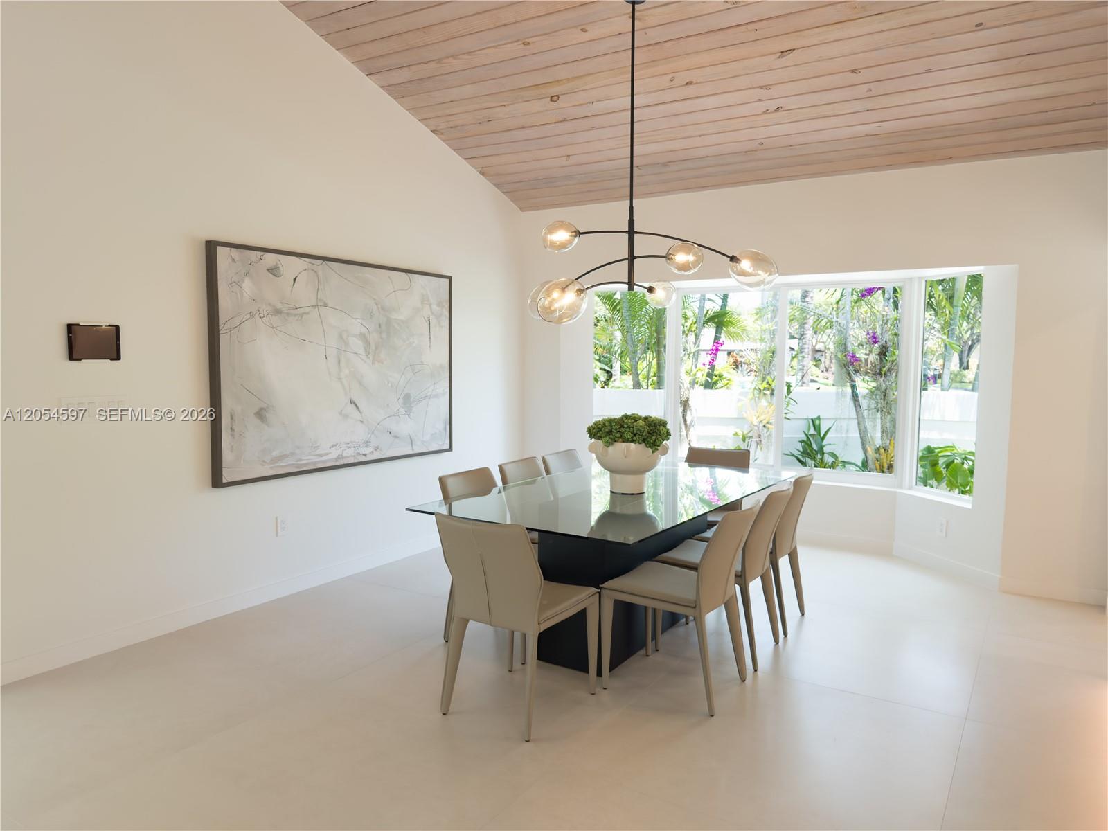 A dining room features a glass-topped table, modern chandelier, and a vaulted wood-paneled ceiling — 11450 SW 92nd Ct, Miami FL 33176, MIAMI, FL