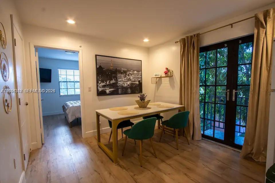 A dining area features a white table with gold legs, green chairs, and French doors — 5911 SW 5th Ter # B, Miami FL 33144, MIAMI, FL
