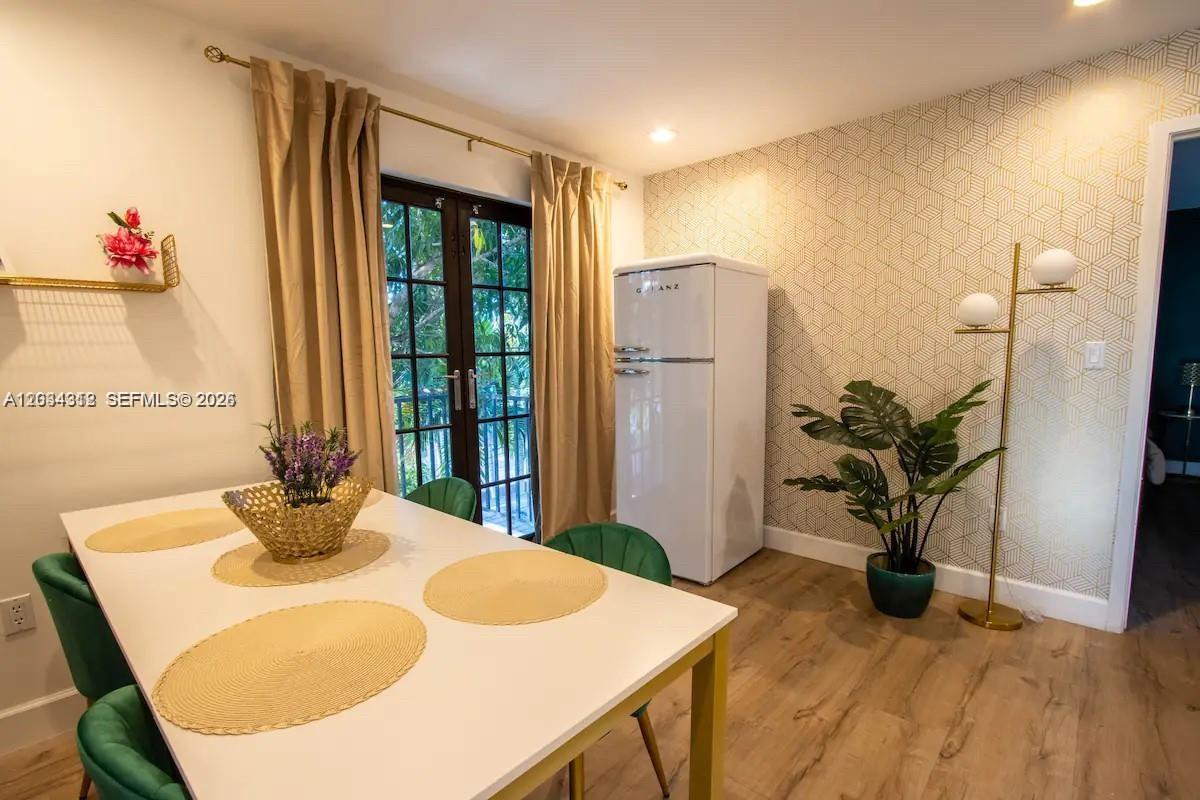 A dining area features a white table, green chairs, a retro refrigerator, and patterned wallpaper — 5911 SW 5th Ter # B, Miami FL 33144, MIAMI, FL