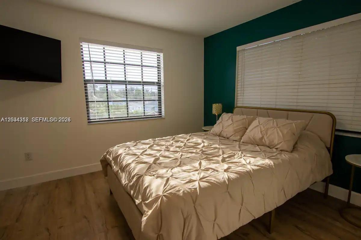A bedroom features a bed with a tan tufted comforter against a dark teal wall — 5911 SW 5th Ter # B, Miami FL 33144, MIAMI, FL