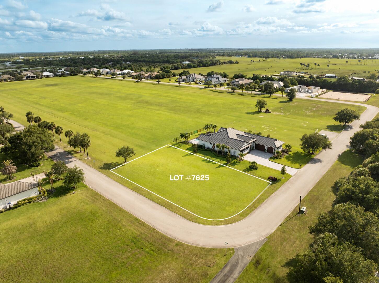 An aerial view shows a vacant, rectangular residential lot outlined in white next to a house — 7625 N Polo Grounds Lane, Vero Beach FL 32966, VERO BEACH, FL