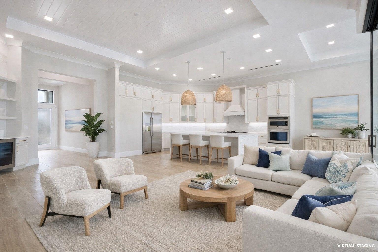 This open-concept living room and kitchen features white cabinetry, a large island, and neutral furniture — 7625 N Polo Grounds Lane, Vero Beach FL 32966, VERO BEACH, FL