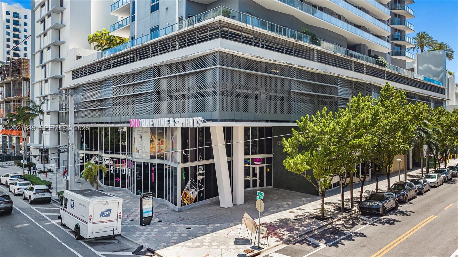 An exterior view of a modern multi-story building with a ground-floor wine and spirits shop — 1010 SW 2nd Ave # 1608, Miami FL 33130, MIAMI, FL