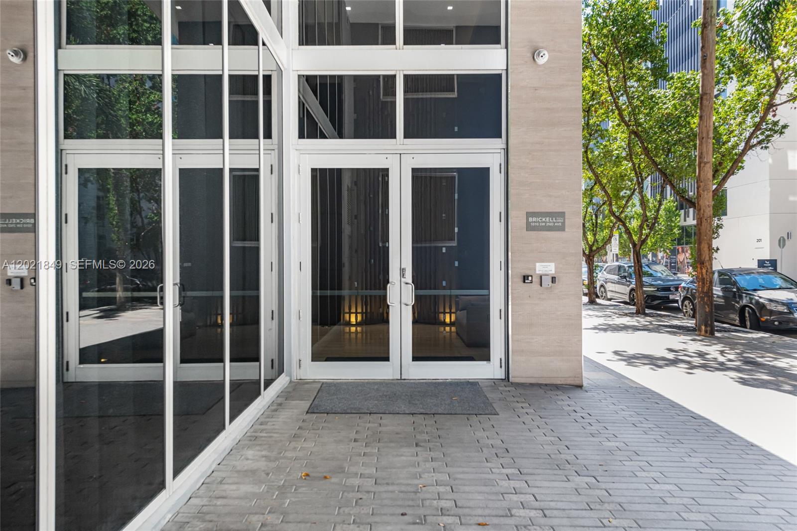 The exterior entrance of a building features glass double doors and a brick walkway — 1010 SW 2nd Ave # 1608, Miami FL 33130, MIAMI, FL