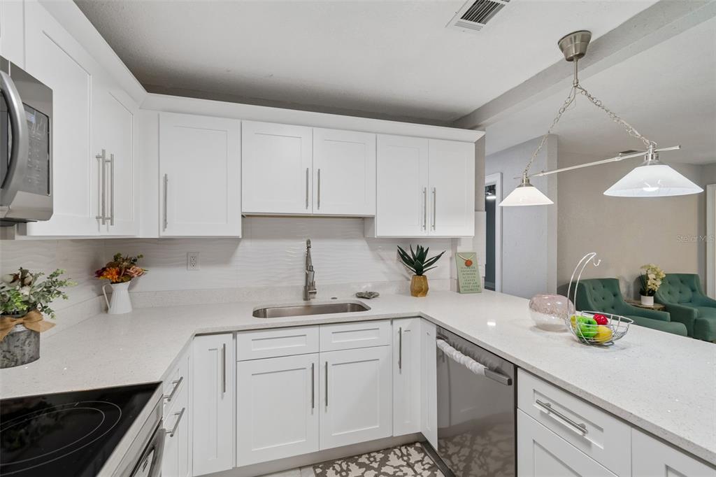 A kitchen with white shaker cabinets, quartz countertops, and a stainless steel sink — 804 VALENCIA ROAD, PLANT CITY, FL