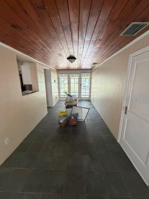 A sunroom features a wood-plank ceiling, dark tile flooring, and a glass-paned door — 1009 E MARKS STREET, ORLANDO, FL