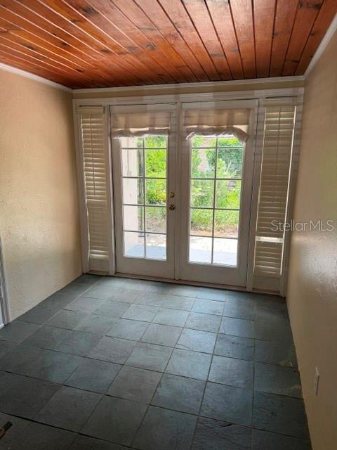A sunroom features slate tile flooring, a wood-paneled ceiling, and French doors with blinds — 1009 E MARKS STREET, ORLANDO, FL