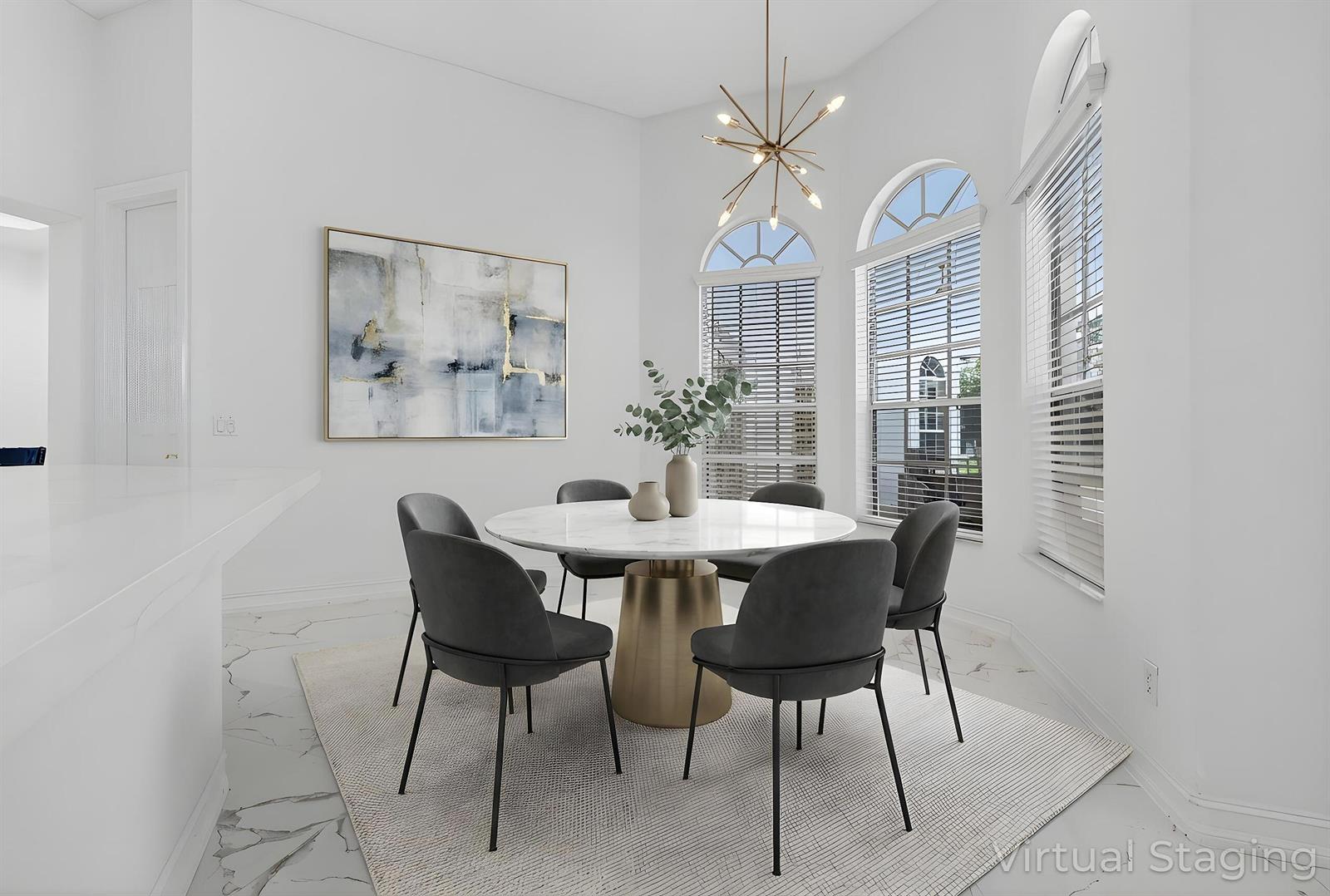 This virtually staged dining room features a round marble table, gray chairs, and arched windows — 14780 Horseshoe Trace, Wellington FL 33414, WELLINGTON, FL