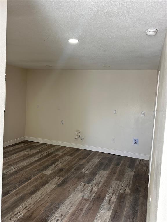 An empty room features wood-look flooring, recessed lighting, and plumbing stubs on the wall — 1716 SPRUCEWOOD LANE, ORLANDO, FL
