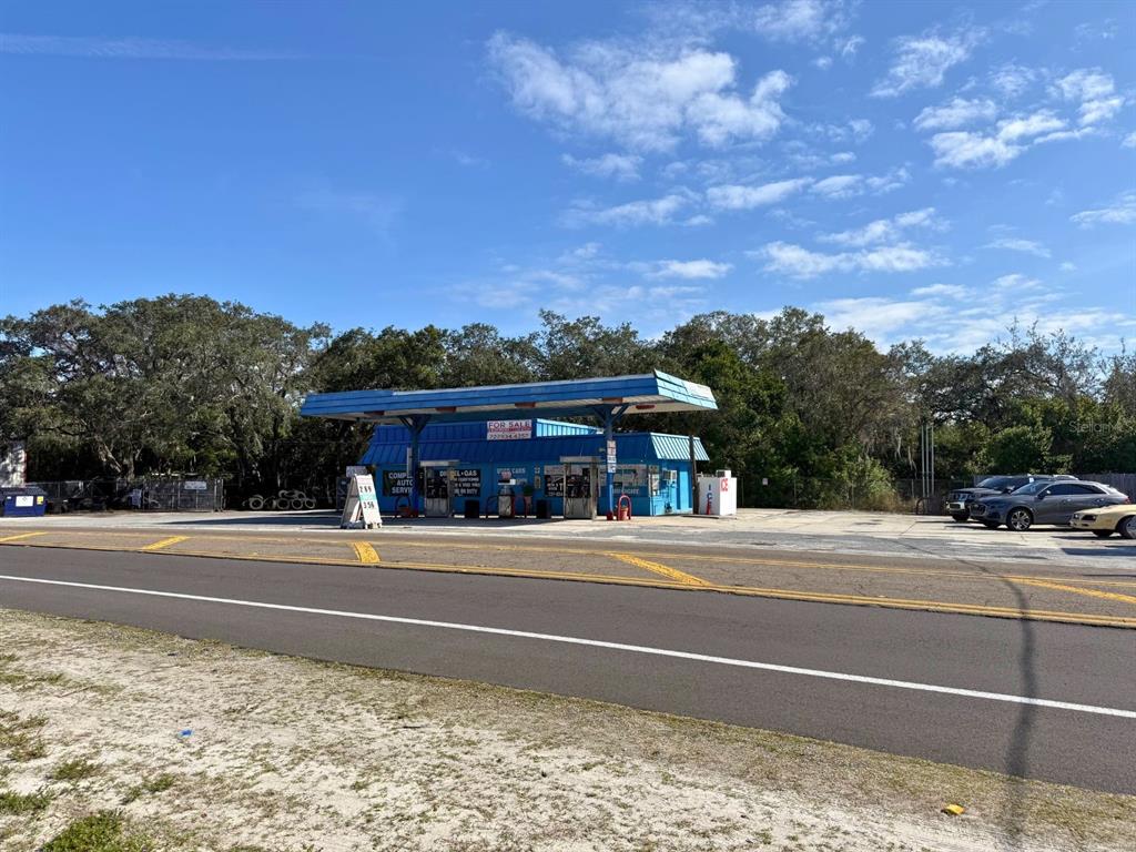 A blue gas station with a canopy stands beside a road under a blue sky — 1941 S PINELLAS AVENUE, TARPON SPRINGS, FL