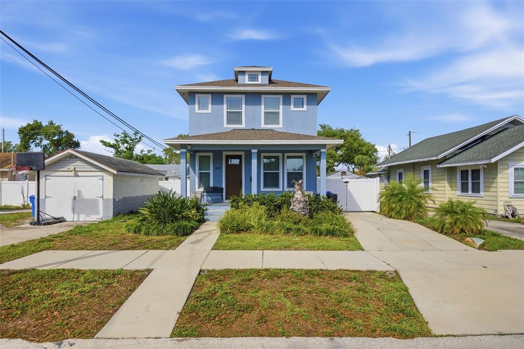 A two-story blue house with a front porch, a detached garage, and a concrete driveway — 3222 PRESCOTT STREET N, ST PETERSBURG, FL