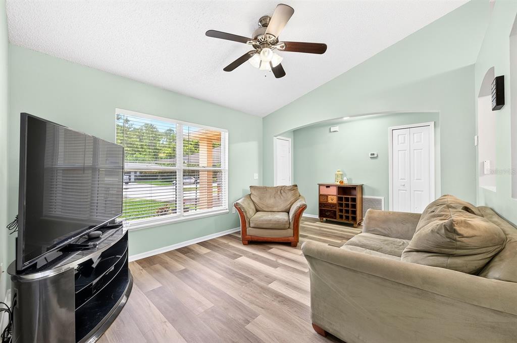 A dining area with a grey table and chairs opens to a kitchen and patio — 3147 UTAH DRIVE, DELTONA, FL