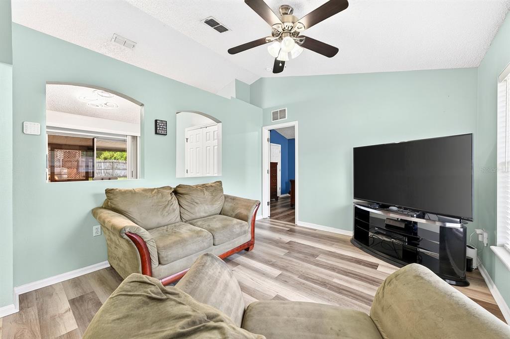 A kitchen features black cabinets, granite countertops, a tiled backsplash, and stainless steel appliances — 3147 UTAH DRIVE, DELTONA, FL