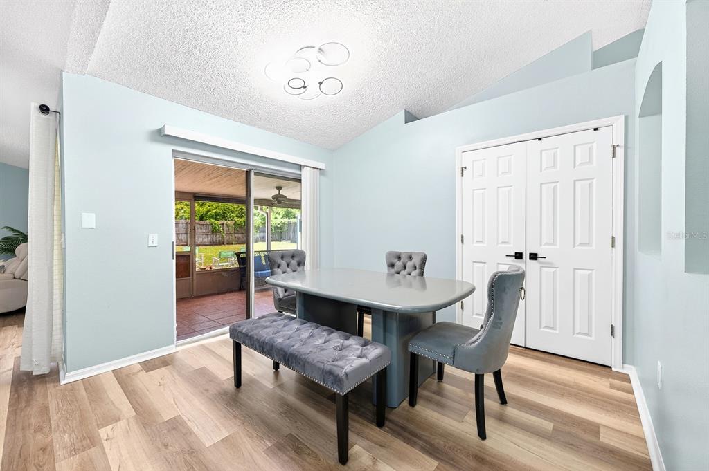 A kitchen with dark cabinets and a breakfast bar opens into a living area — 3147 UTAH DRIVE, DELTONA, FL