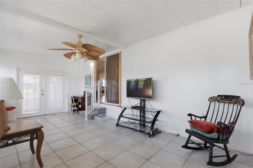 A sunroom with white walls, tile flooring, a ceiling fan, and a television on a stand — 5246 AMANDA STREET, ZEPHYRHILLS, FL