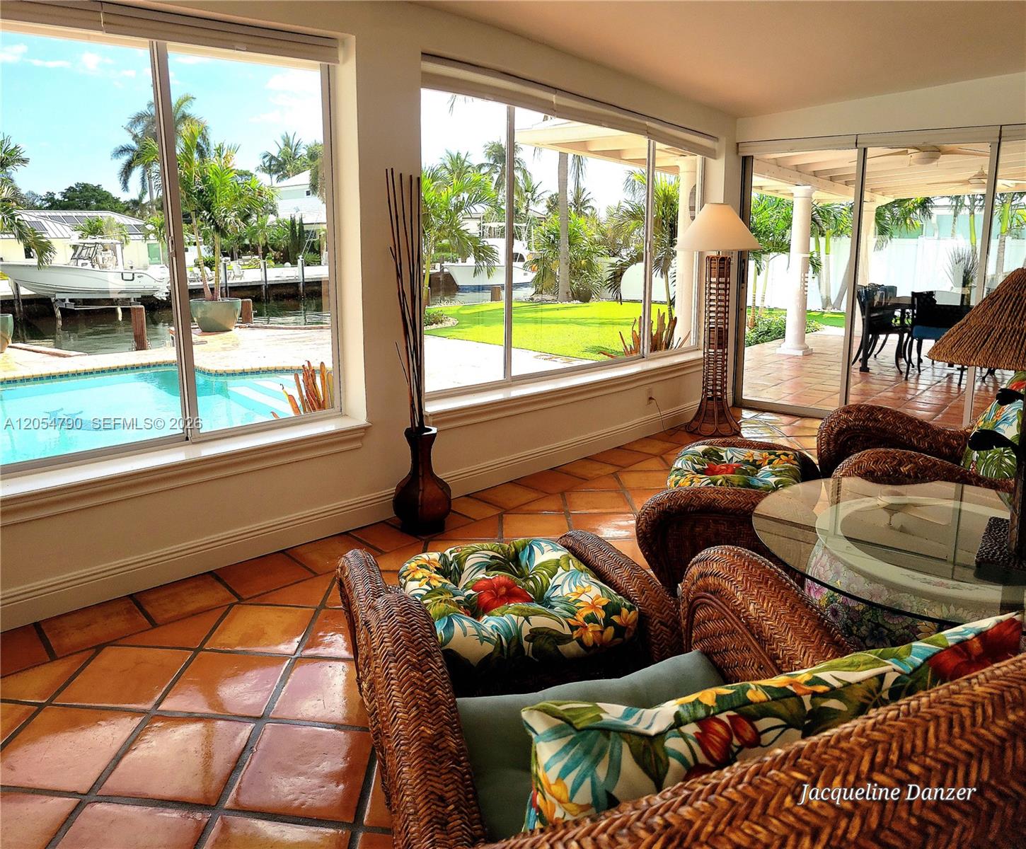 A sunroom with terracotta tile floors overlooks a swimming pool, canal, and boat dock — 2781 NE 23rd Ct # 2781, Pompano Beach FL 33062, POMPANO BEACH, FL
