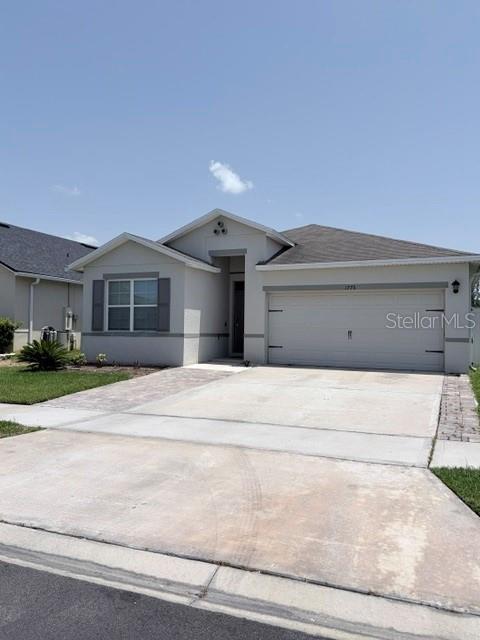 A single-story suburban house with a two-car garage and a concrete driveway — 1776 RANGER HIGHLANDS ROAD, KISSIMMEE, FL