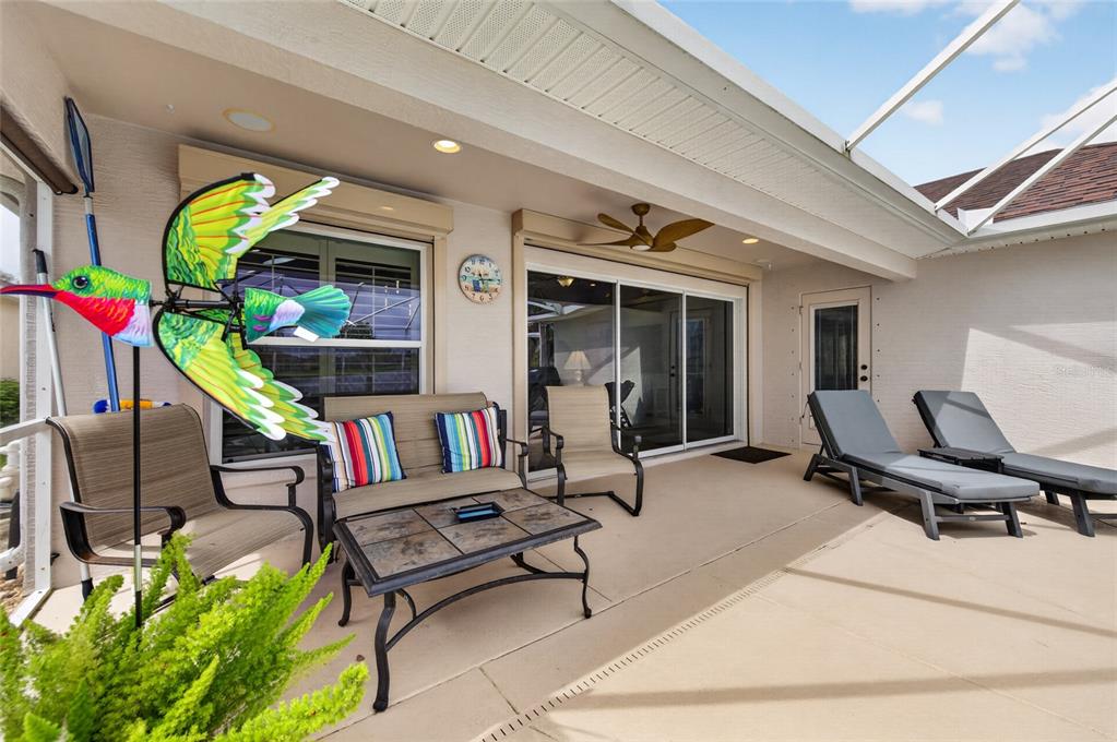 An entryway features light blue walls, tile flooring, a glass-paneled front door, and a bathroom — 3385 TESORO CIRCLE, NEW SMYRNA BEACH, FL