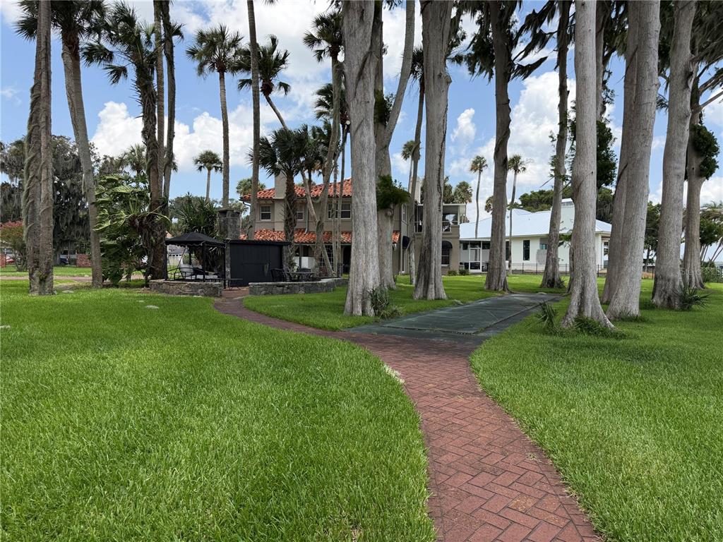 A two-story Mediterranean-style house with a stucco exterior, red tile roof, and brick driveway — 801 LAKE SHORE DRIVE, LEESBURG, FL