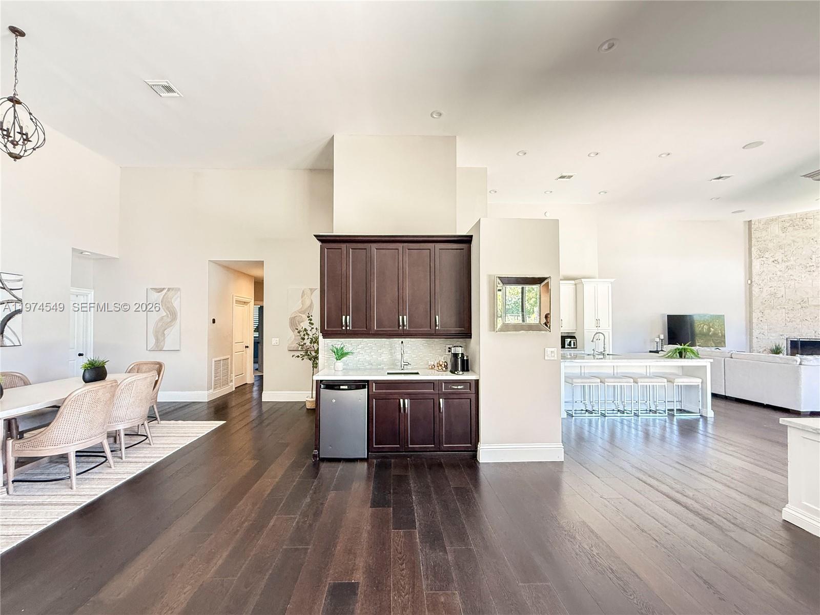 A kitchen area features dark wood cabinets, a wet bar, and light hardwood flooring — 400 Alexandra Cir # 0, Weston FL 33326, WESTON, FL