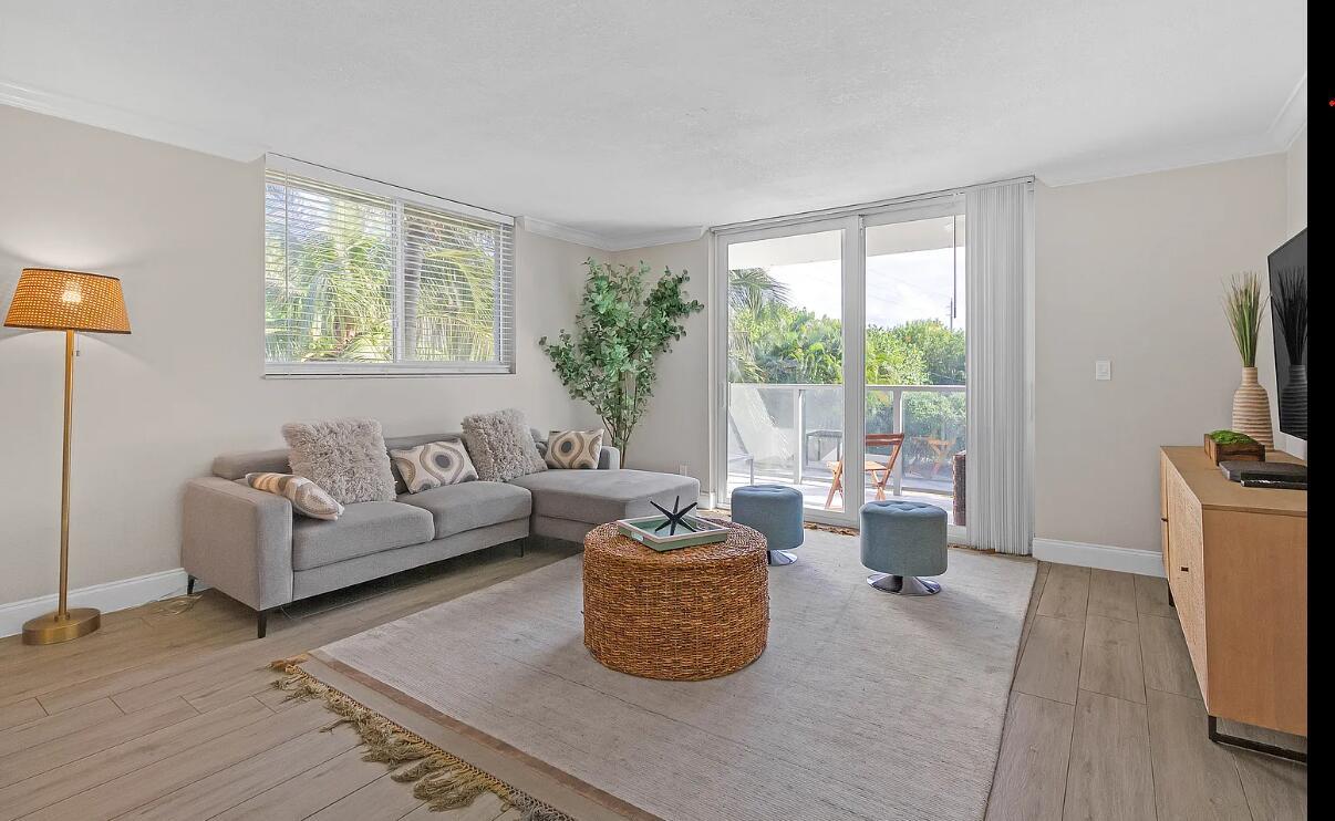 A living room features a gray sectional sofa, a woven coffee table, and a balcony view — 601 N Ocean Boulevard, Boca Raton FL 33432, BOCA RATON, FL