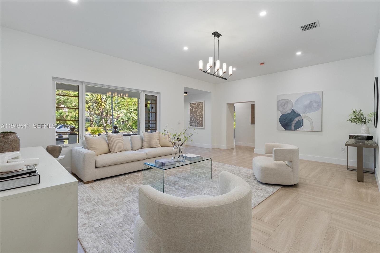 A bright living room features a white sofa, two armchairs, a glass coffee table, and light-colored flooring — 420 NE 55th Ter, Miami FL 33137, MIAMI, FL