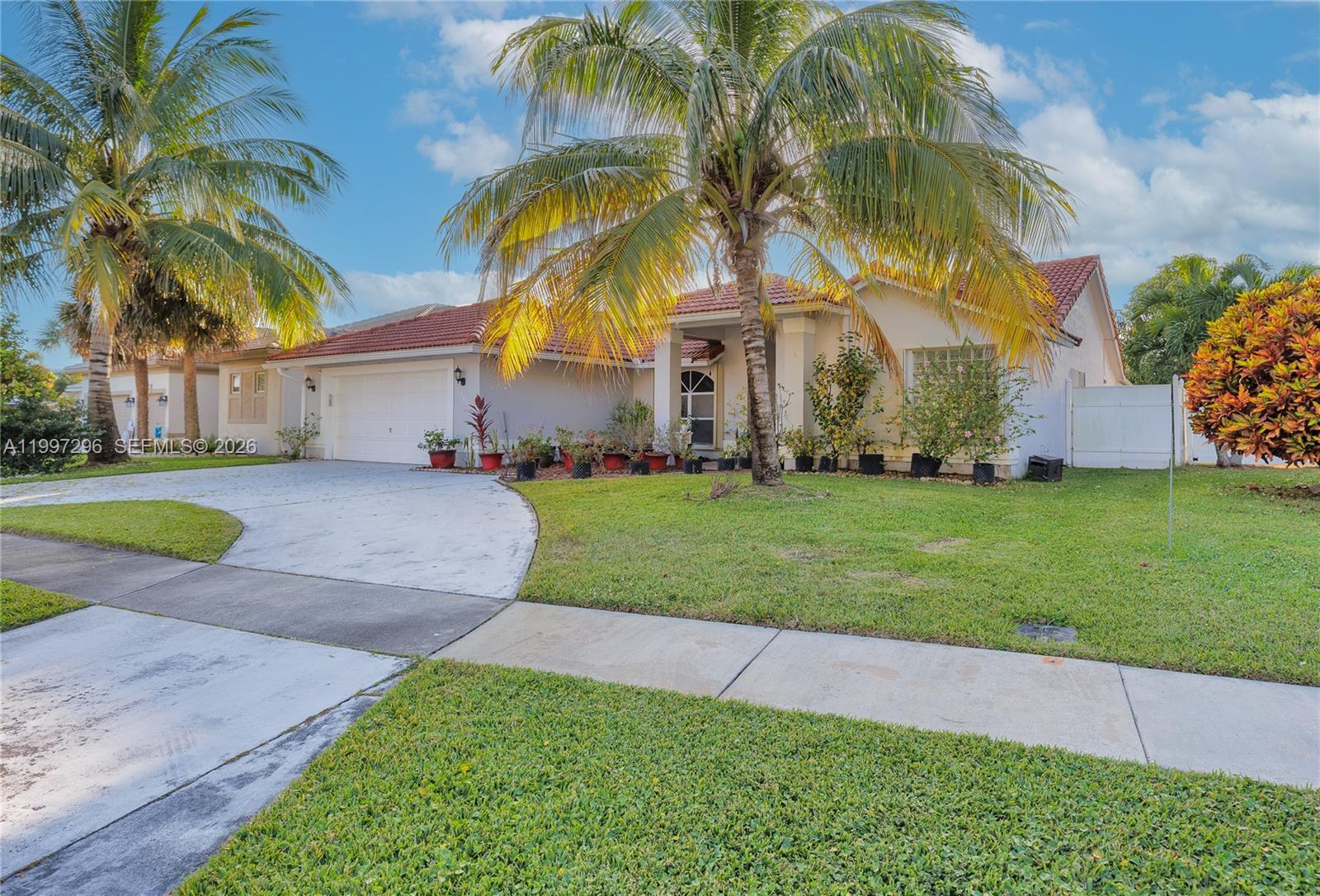 A single-story house with a white exterior, red tile roof, and a palm tree — 3462 Harness Cir # 0, Wellington FL 33449, WELLINGTON, FL