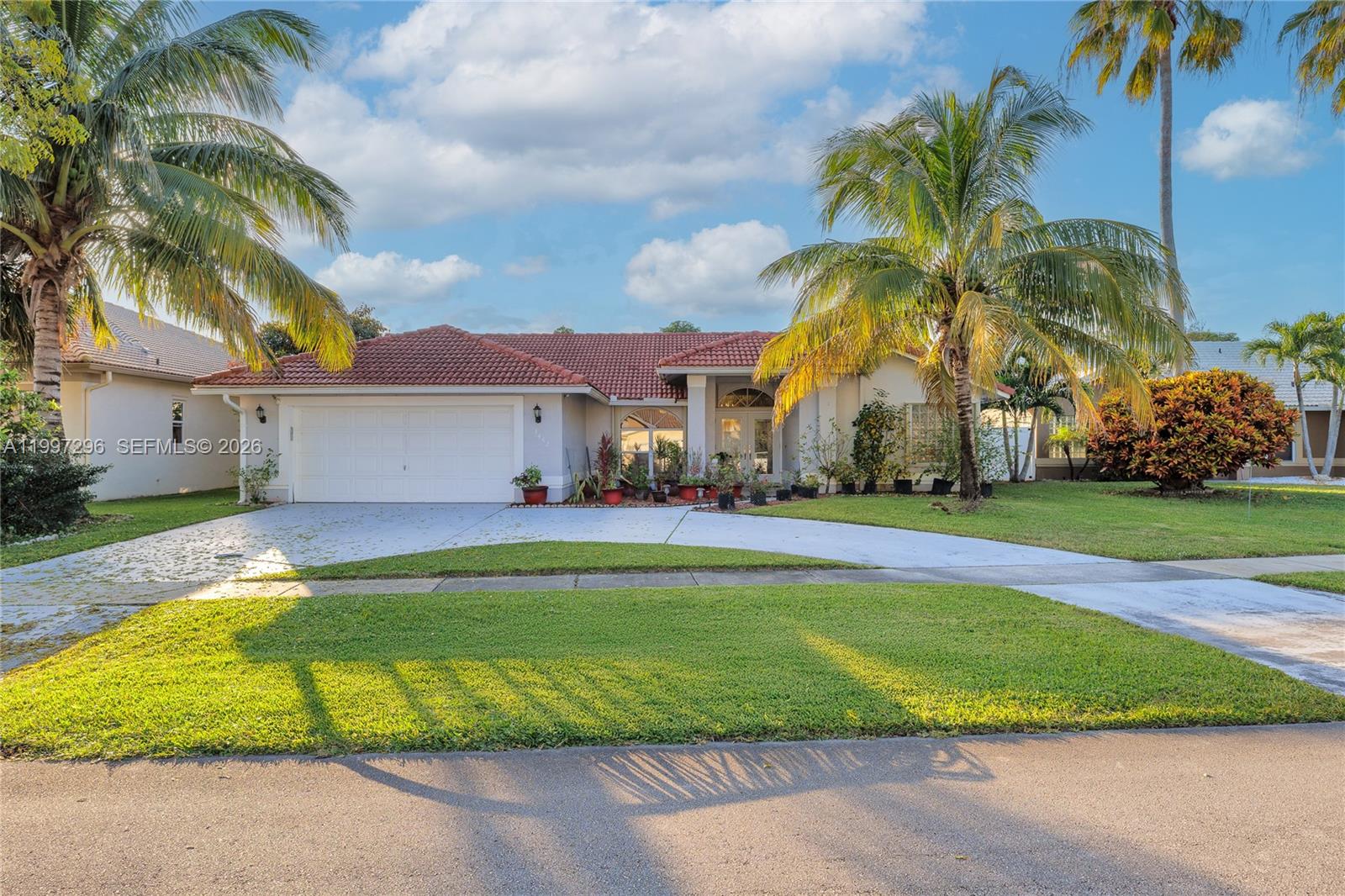 A single-story house with a red tile roof, a two-car garage, and palm trees — 3462 Harness Cir # 0, Wellington FL 33449, WELLINGTON, FL