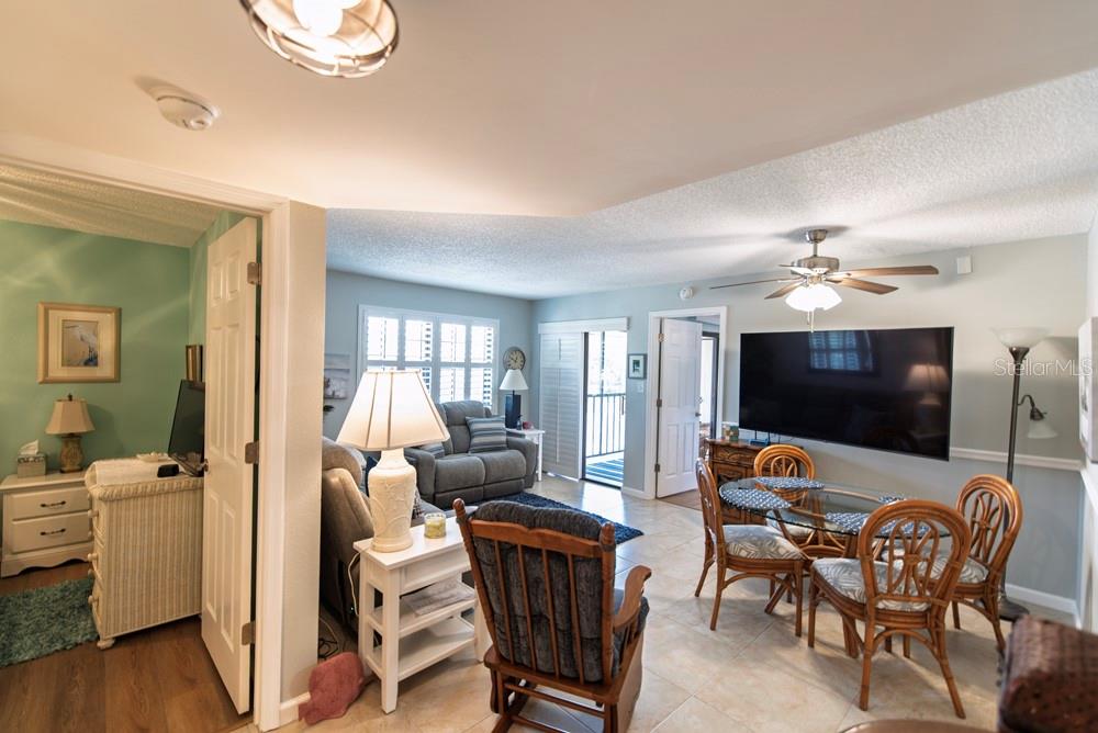 An open-concept living and dining area with tile flooring, a ceiling fan, and a balcony — 19505 QUESADA AVENUE UNIT RR202, PORT CHARLOTTE, FL