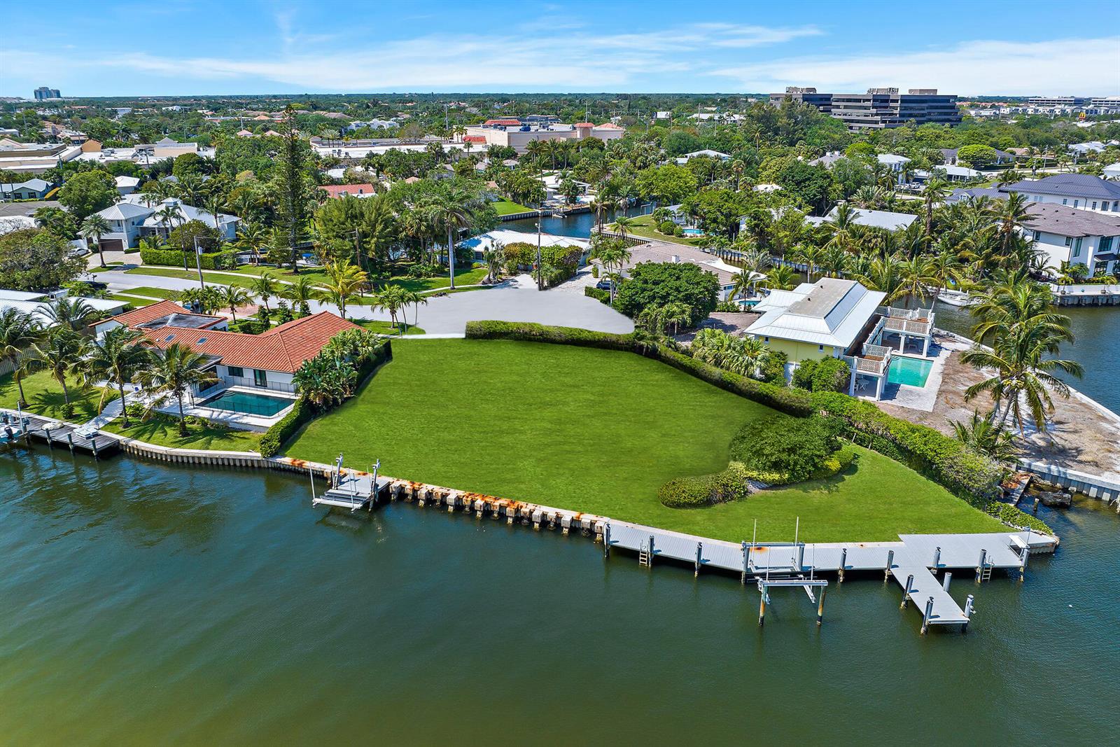 An aerial view shows a large waterfront lot with a grassy lawn and private docks — 1454 Point Way, North Palm Beach FL 33408, NORTH PALM BEACH, FL