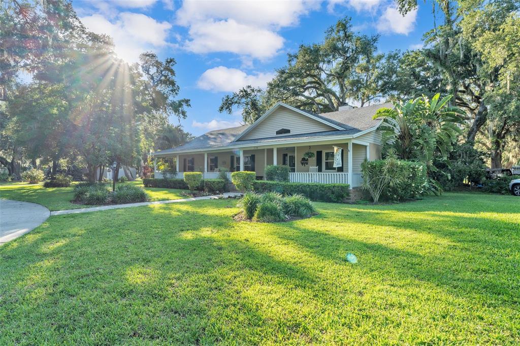A one-story house with a covered front porch sits on a large, grassy lawn — 5108 WATERWOOD DRIVE, BARTOW, FL