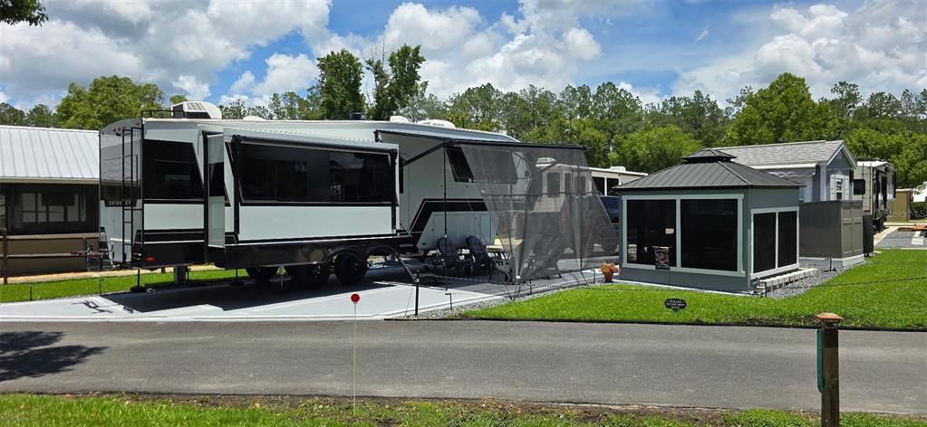 A recreational vehicle with a slide-out is parked on a concrete pad next to a gazebo — 2850 NE 103RD TERRACE, SILVER SPRINGS, FL