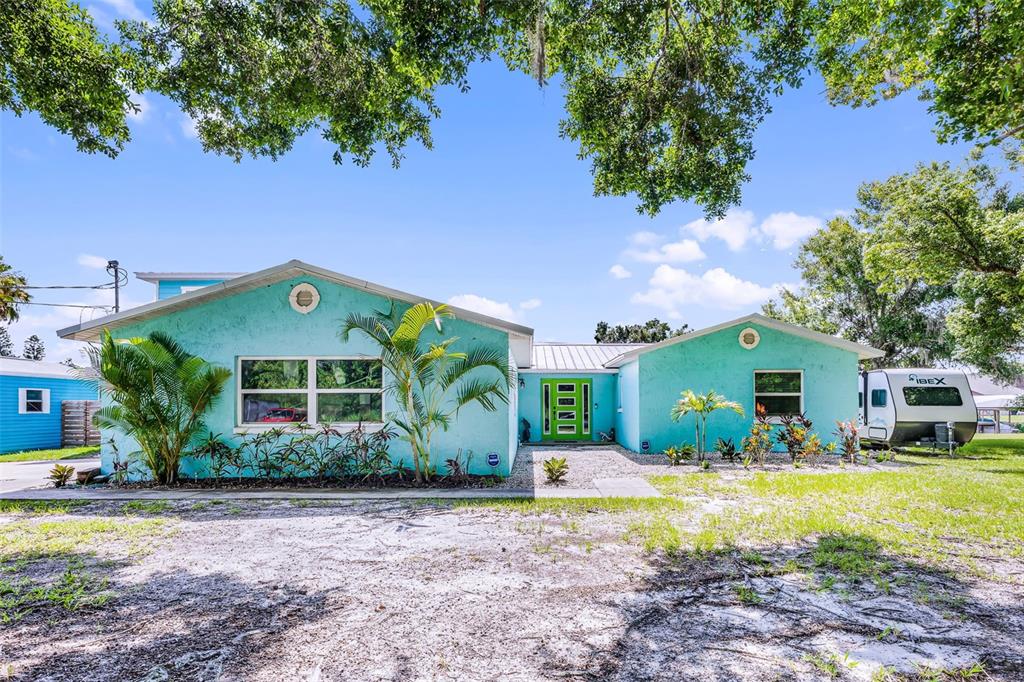 A turquoise, single-story house with a bright green front door and a parked travel trailer — 1811 MISSOURI AVENUE, SANFORD, FL