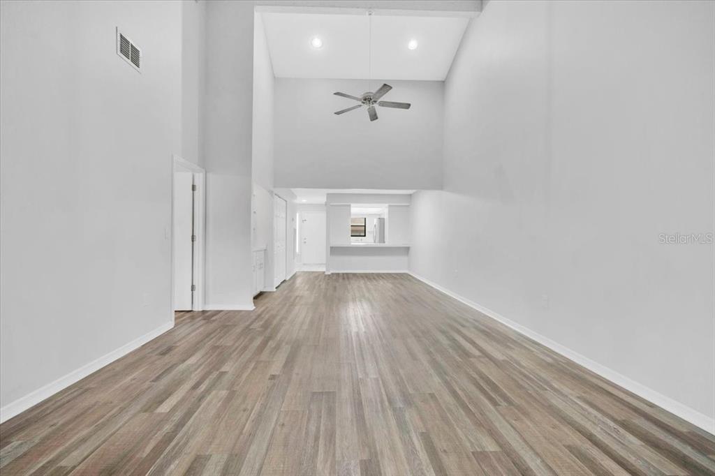 An empty room with high ceilings, a ceiling fan, and light wood-look flooring — 2025 SYLVESTER ROAD UNIT MM4, LAKELAND, FL