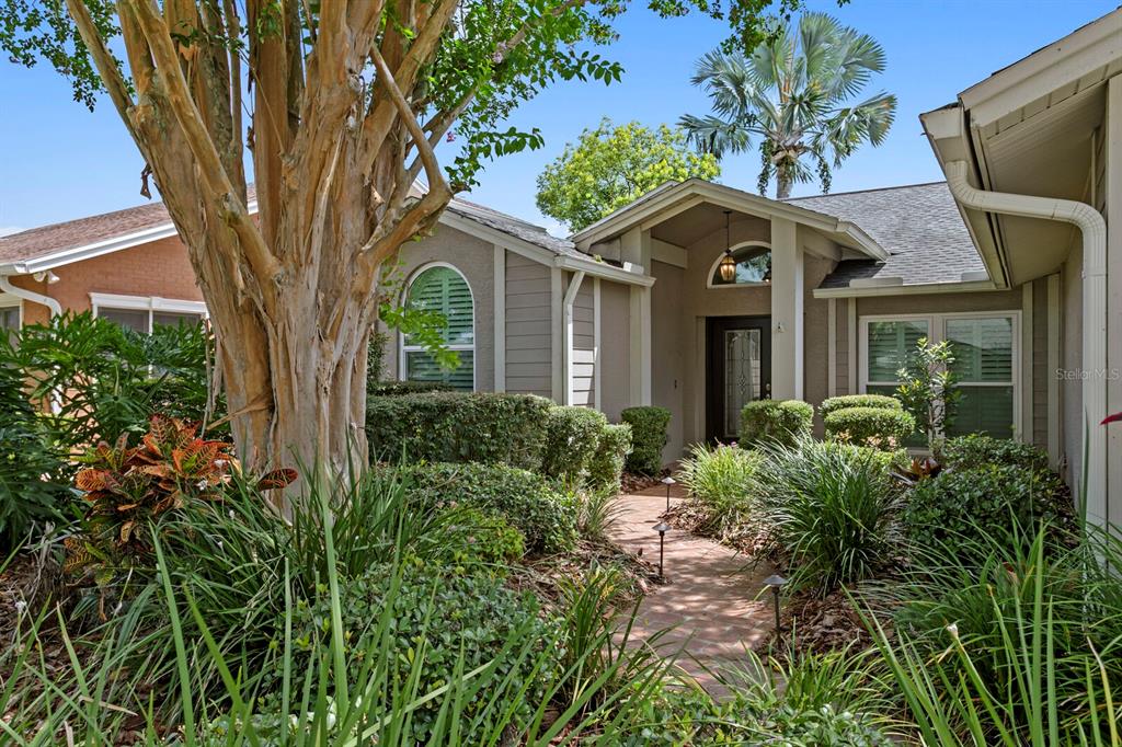The exterior of a single-story house features a brick walkway leading to the front entrance — 14607 VILLAGE GLEN CIRCLE, TAMPA, FL
