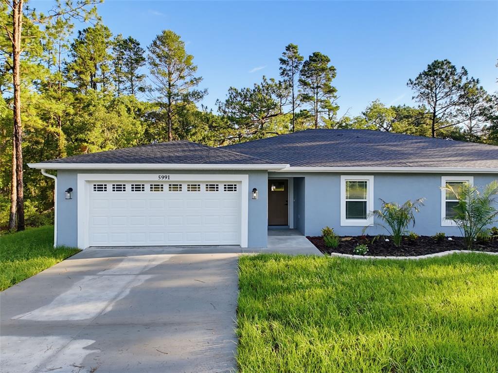 A single-story house with a gray exterior, a two-car garage, and a concrete driveway — 5987 W OAK PARK BOULEVARD, HOMOSASSA, FL
