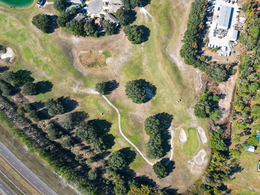 An aerial view of a golf course hole with a putting green and sand traps — 4460 GOLF CLUB LANE, SPRING HILL, FL