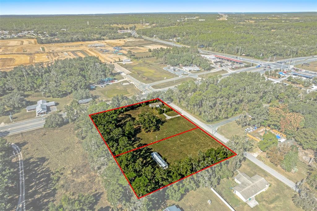 An aerial view shows two adjacent rectangular lots outlined in red containing trees and structures — 3228 & 3164 W LAUREL STREET, LECANTO, FL