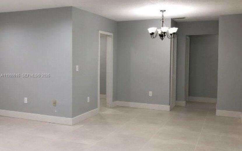 An interior view of a room with light gray walls, white trim, and tile flooring — 930 Benevento Ave # 930, Coral Gables FL 33146, CORAL GABLES, FL