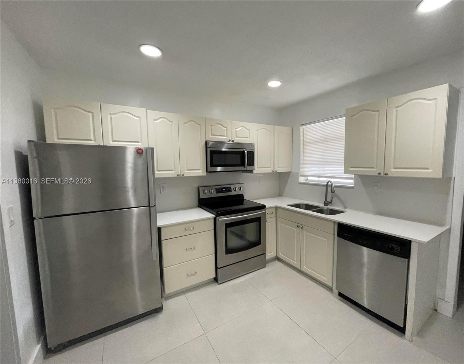 A kitchen features white cabinets, stainless steel appliances, and light-colored tile flooring — 930 Benevento Ave # 930, Coral Gables FL 33146, CORAL GABLES, FL