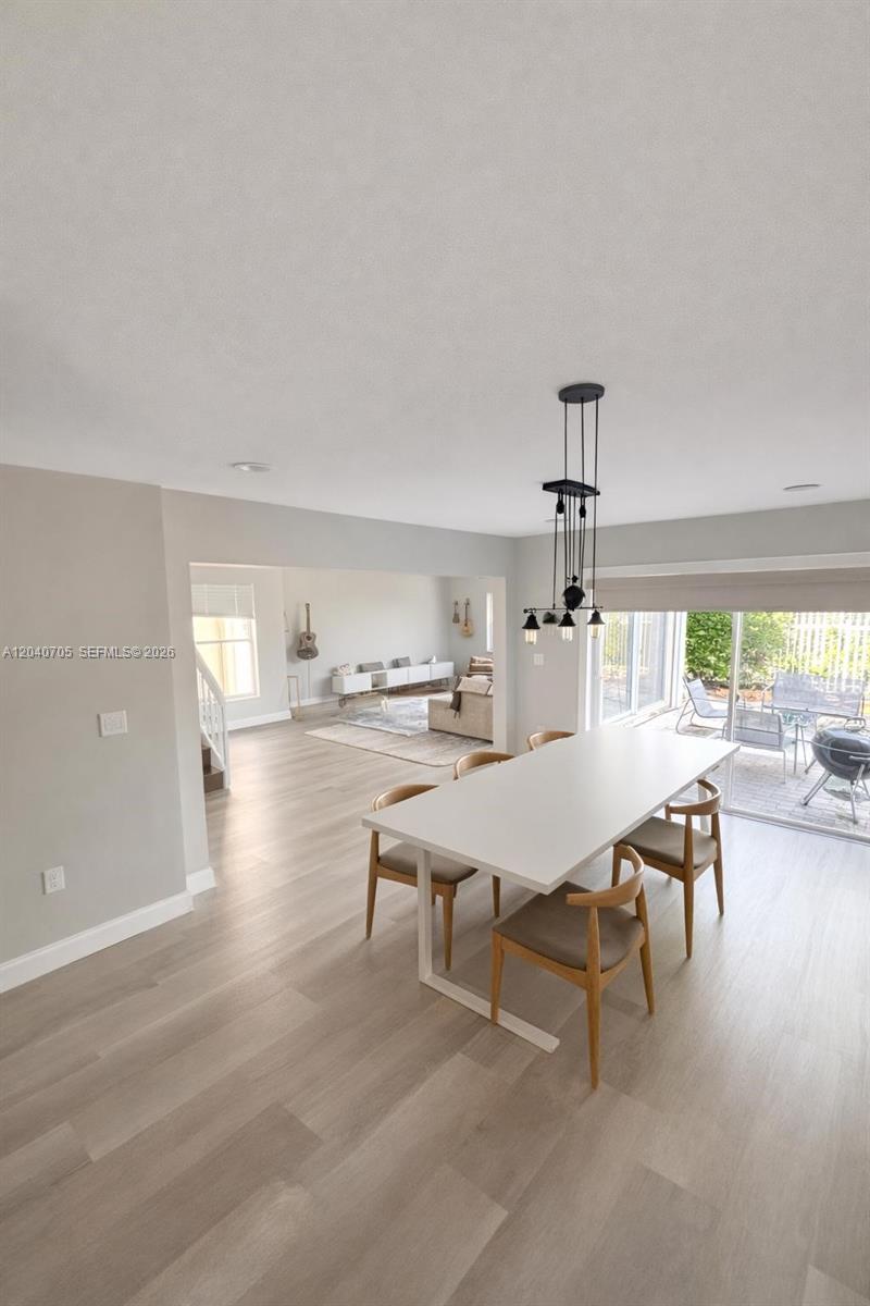 A dining area with a white table and chairs opens into a living room — 1125 Butternut Ln, Hollywood FL 33019, HOLLYWOOD, FL
