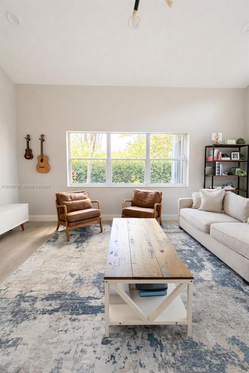 A living room features a large window, two leather armchairs, a sofa, and a coffee table — 1125 Butternut Ln, Hollywood FL 33019, HOLLYWOOD, FL