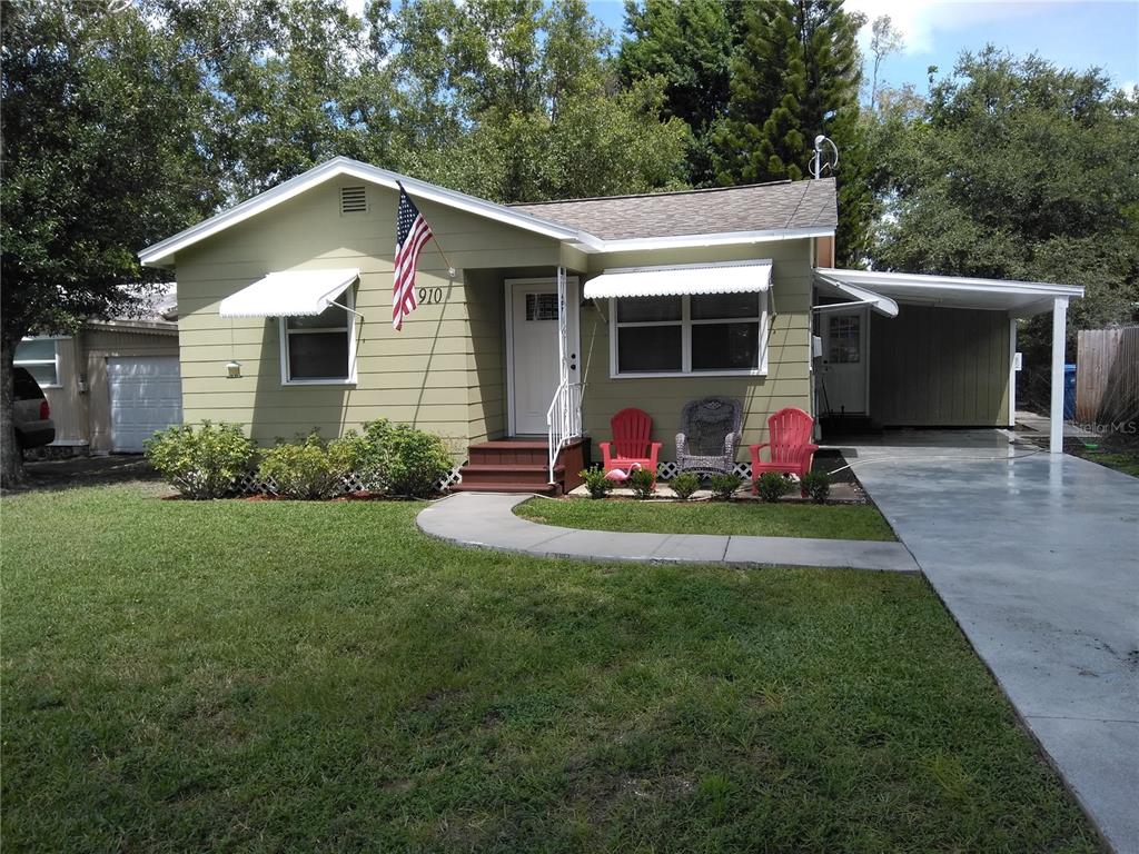 A single-story house with light green siding, a front porch, and an attached carport — 910 9TH AVENUE SW, LARGO, FL
