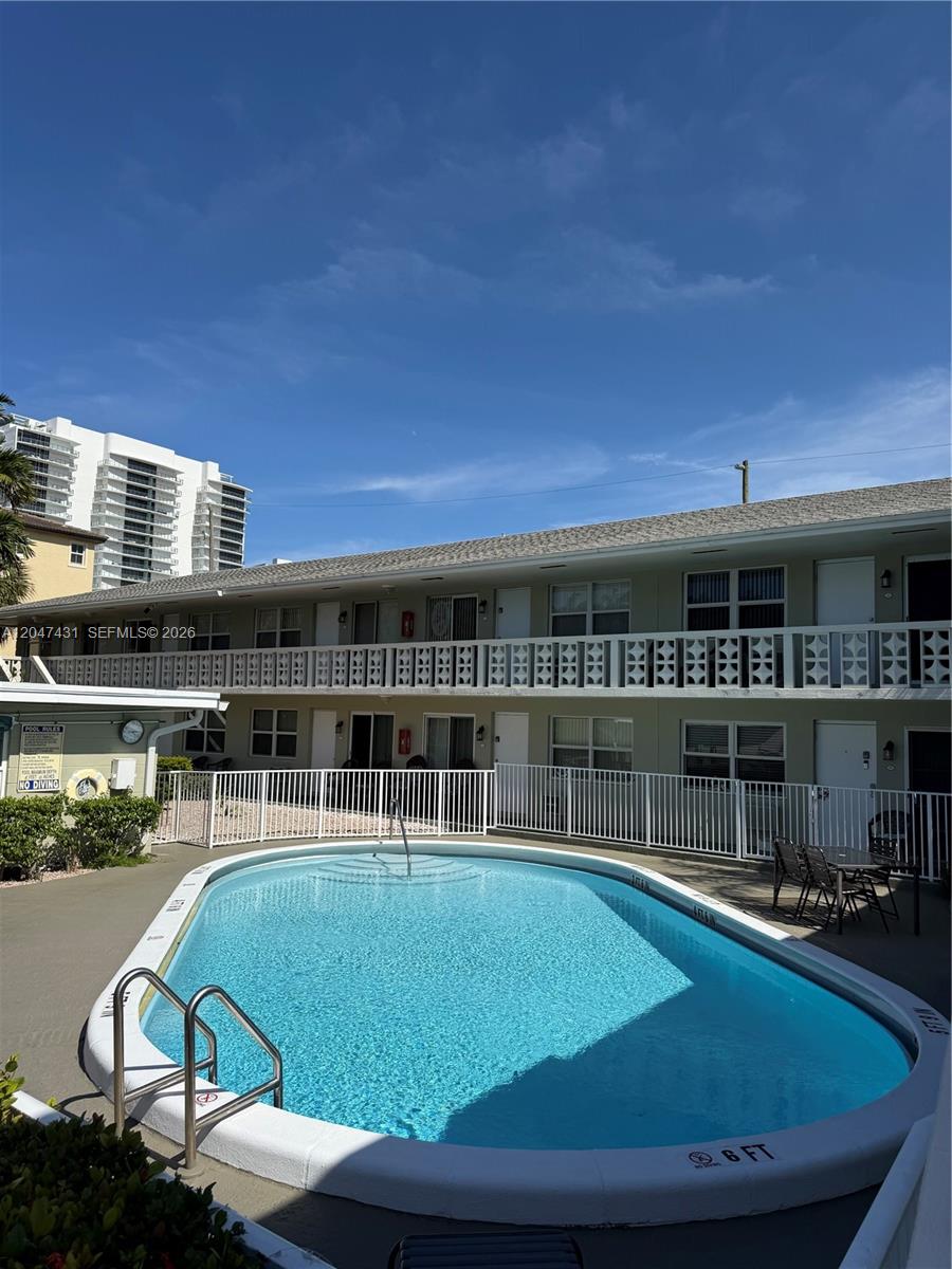 An outdoor swimming pool is situated in front of a two-story apartment building — 3230 NE 13th St # 2, Pompano Beach FL 33062, POMPANO BEACH, FL
