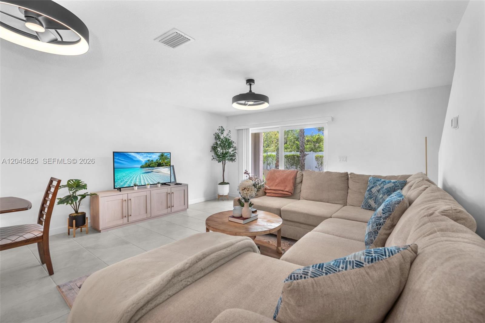 A living room features a beige sectional sofa, a wooden coffee table, and a television — 4226 Bent River Rd, Lake Worth FL 33467, LAKE WORTH, FL