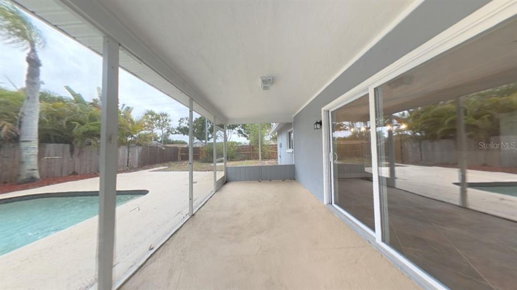 A covered patio overlooks a swimming pool and a fenced backyard — 8990 123RD WAY, SEMINOLE, FL