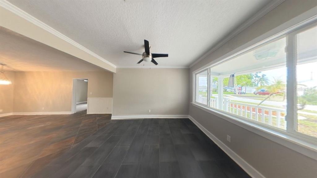 A living room features dark tile flooring, a ceiling fan, and large windows — 8990 123RD WAY, SEMINOLE, FL